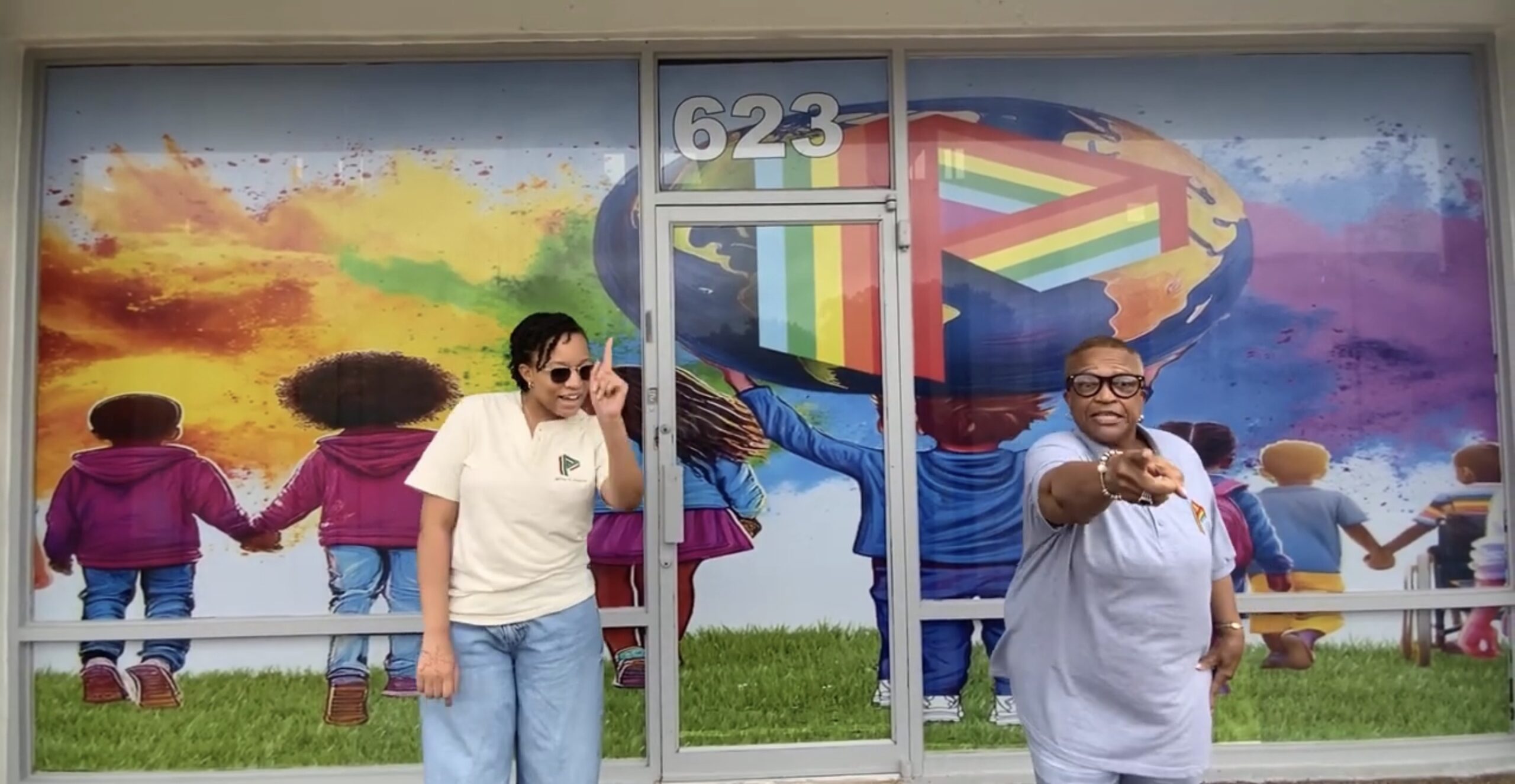 Two Women Pointing Towards The Camera